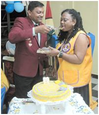 Lt Surujpaul Singh gives a piece of cake to N/A Lions Club President, Lt T. Lewis, during the cutting of the cake